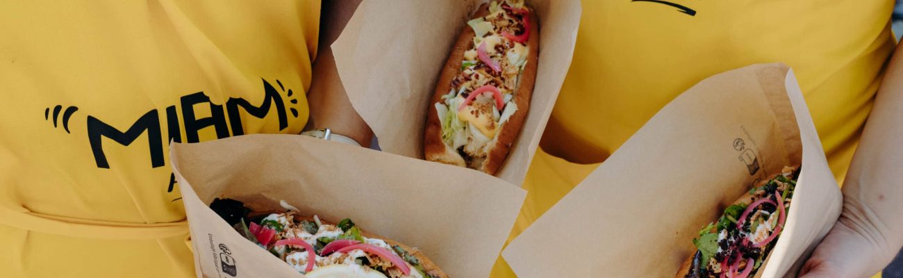 des personnes qui montrent de la street food type hot dog